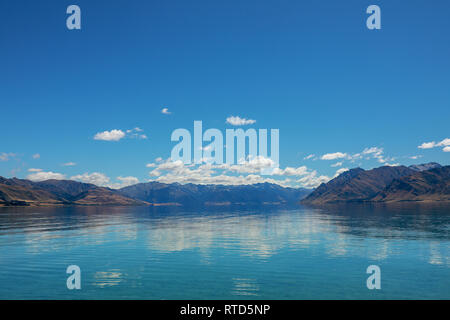 Magnifique Lac Hawea en été, ciel bleu de l'eau claire les roches cailloux nuages Nouvelle-zélande Île du Sud Banque D'Images