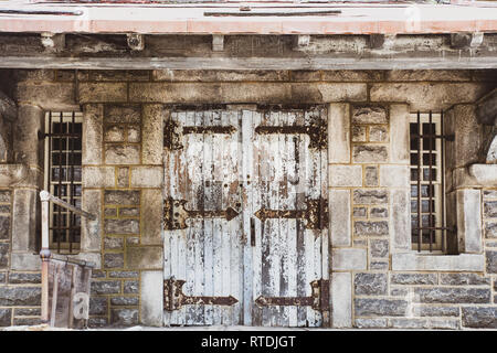 Porte usé avec l'écaillage de la peinture sur bâtiment en pierre abandonnée Banque D'Images