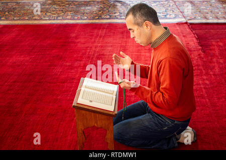 L'homme musulman à lire le Coran à la mosquée Banque D'Images