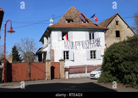 26 février 2019, la France (France), Entzheim : l'alsacien et drapeaux français ainsi que le drapeau de l'aile droite du mouvement extrémiste 'Bastion' Social se suspendre à une maison alsacienne dans la municipalité d'Entzheim. Des sympathisants du mouvement ont récemment occupé deux maisons ici. Le groupe est d'être interdits en raison de l'anti-sémitisme en France. (Dpa ''C'est une honte" - la France et l'incendie de la haine des juifs' à 01.03.2019) (dpa ''C'est une honte" - la France et l'incendie de la haine des juifs' à 01.03.2019) Photo : Violetta Heise/dpa Banque D'Images