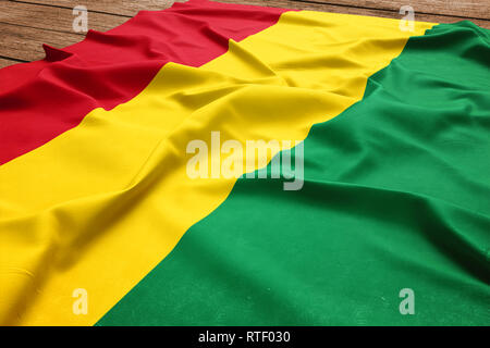 Drapeau de la Bolivie sur un bureau en bois. Drapeau bolivien soie vue d'en haut. Banque D'Images