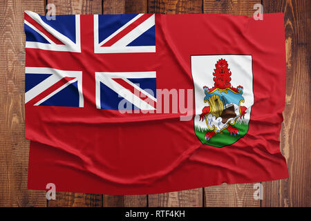 Pavillon de l'Bermudes sur une table en bois. Drapeau bermudien froissé vue d'en haut. Banque D'Images