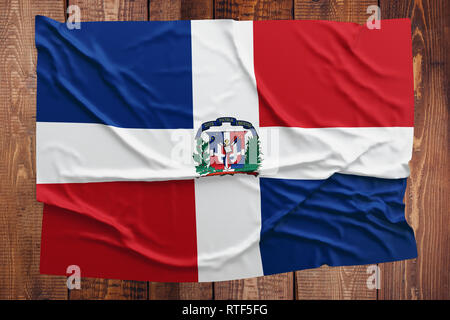 Drapeau de la République dominicaine sur un arrière-plan de table en bois. République Dominicaine froissé drapeau haut vue. Banque D'Images