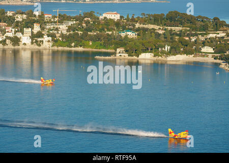 Deux Canadair CL-415 se remplissant dans la baie abritée de Villefranche-sur-Mer pour combattre un brushfire à proximité. Côte d'Azur, France. Banque D'Images