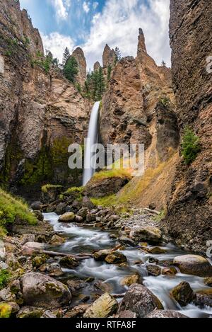 Cascade s'écoule à travers le paysage érodé avec aiguilles de roche, Tour Tour de l'automne avec Creek, Parc National de Yellowstone, Wyoming, USA Banque D'Images