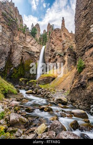 Cascade s'écoule à travers le paysage érodé avec aiguilles de roche, Tour Tour de l'automne avec Creek, Parc National de Yellowstone, Wyoming, USA Banque D'Images