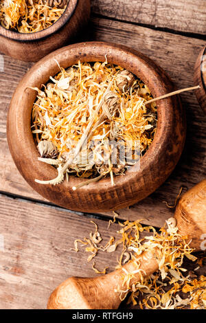 Herbes médicinales. Fleurs calendula séché dans le mortier Banque D'Images