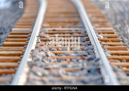 Gros plan d'une voie de chemin de fer sur un terrain rocheux. Vue rapprochée d'une voie de chemin de fer sur une journée ensoleillée. La voie de chemin de fer passe à travers un terrain accidenté Banque D'Images