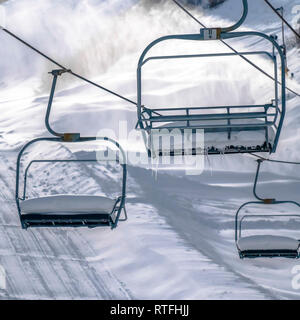 Frosty télésièges contre soleil, la neige en hiver. Télésièges vide avec de la neige couvrant les sièges à Park City, Utah. Pente couverte de sunlit sharp w Banque D'Images