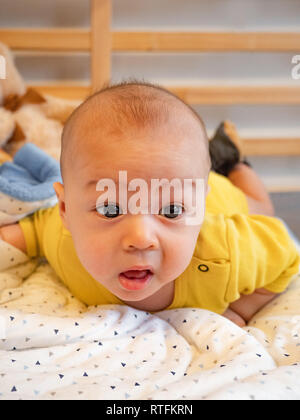 4 mois mixed race woman asiatiques à heureux sourire et rire à l'appareil photo, Enfants en santé bébé garçon. Bébé commence à ramper Banque D'Images