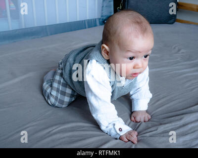 4 mois mixed race woman asiatiques à heureux sourire et rire à l'appareil photo, Enfants en santé bébé garçon. Bébé commence à ramper Banque D'Images