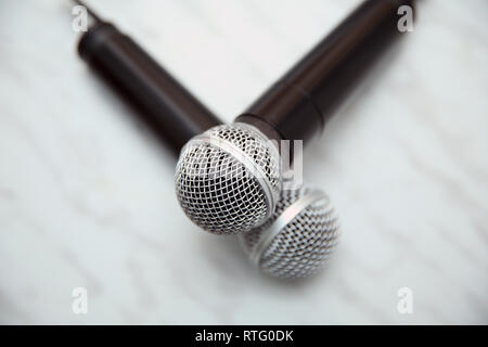 Close up 2 microphone pour chanter une chanson duo concept . Deux microphones d'argent plus isolé sur fond blanc Banque D'Images