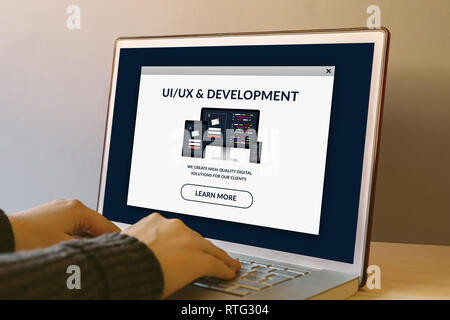 UI/UX design et concept de développement sur l'écran de l'ordinateur portable sur une table en bois. Mains de la saisie sur un clavier. Tous les contenu de l'écran est conçu par moi. Banque D'Images