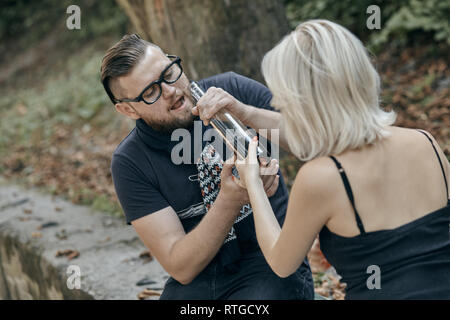 Couple assis sur la table et de boire de l'alcool. Drunk jeunes (l'alcoolisme dans la famille, la douleur, la pitié, le désespoir, problème social de la dépendance, de Banque D'Images