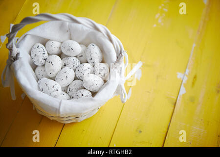 Oeufs de caille en blanc panier en osier. Le concept de vacances de Pâques Banque D'Images