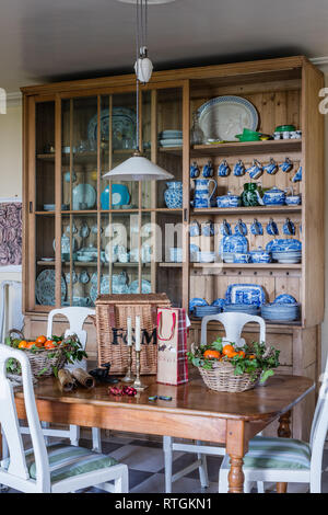 Le pin, à la façade de verre cuisine commode avec espace pour enregistrer des jeux de table et des paniers de fruits sur une table Banque D'Images