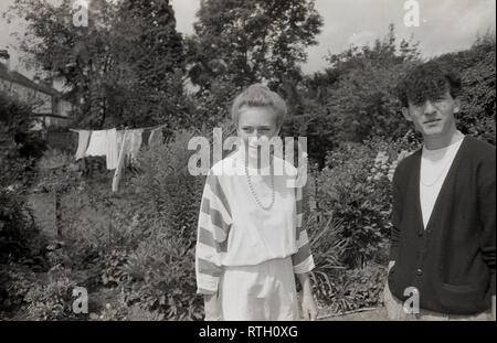 Datant des années 1970, une ancienne.. couple rester ensemble dans une banlieue anglaise jardin arrière, England, UK. Banque D'Images