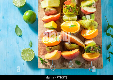 Délicieux mélange de brochettes de fruits pour le goûter Banque D'Images