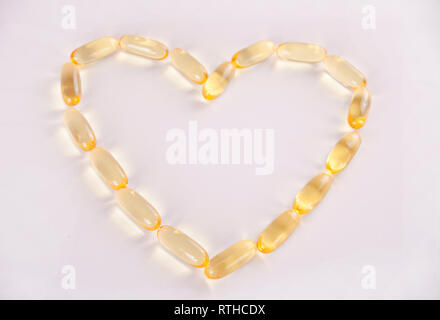 Capsules d'huile de poisson en forme de coeur. Des vitamines pour la promotion de la santé. Concept photo. Banque D'Images