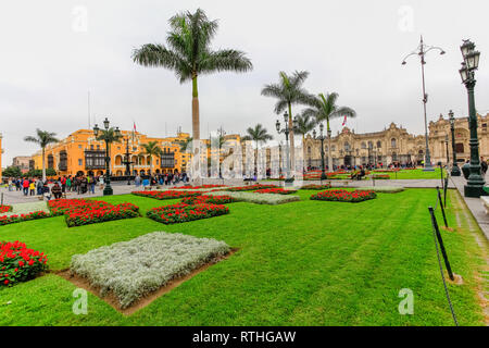 Lima Pérou, juin 2018 : les jardins de couleurs vives de la Plaza de Armas de la ville de Lima, contraste avec un jour gris typique de la ville. Banque D'Images
