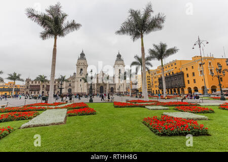 Lima Pérou, juin 2018 : les jardins de couleurs vives de la Plaza de Armas de la ville de Lima, contraste avec un jour gris typique de la ville. Banque D'Images