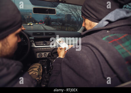 Après le succès du vol de banque, les voleurs sont dans la voiture montrant outre de leur argent et de célébrer la victoire sur le droit qu'ils avaient. Banque D'Images