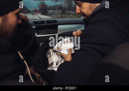 Après le succès du vol de banque, les voleurs sont dans la voiture montrant outre de leur argent et de célébrer la victoire sur le droit qu'ils avaient. Banque D'Images