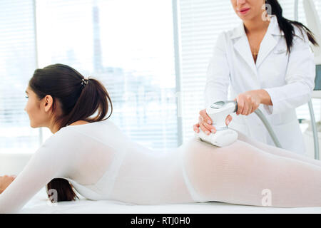 Femme patient est allongé sur une table médicale en fonction de l'objet de procédure de GPL et de graisse réduction de la cellulite. La thérapie de massage LPG beauté donne un excellent resul Banque D'Images