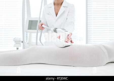 Procédure pour la cellulite massage GPL et la réduction de la graisse. Portrait femme en blanc body massage anti-cellulite obtenir sur les zones à problèmes du corps, c Banque D'Images