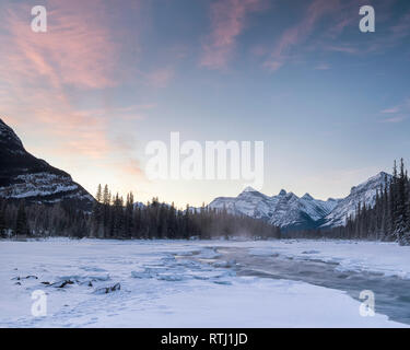 Une longue exposition de droit de la rivière Athabasca, au-dessus de la rivière Athabasca Falls, au lever du soleil en hiver avec la neige a couvert des banques, du Parc National de Jasper, Canada Banque D'Images