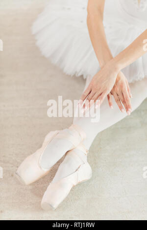 Danseuse assise sur le sol avec les jambes croisées. close up photo recadrée, position finale de la performance, Swan Lake Banque D'Images