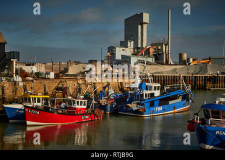 Bateaux dans Whitstable Harbour avec Brett usine agrégats dans l'arrière-plan sur un ciel bleu jour, Whitstable, Kent, Angleterre, Royaume-Uni Banque D'Images