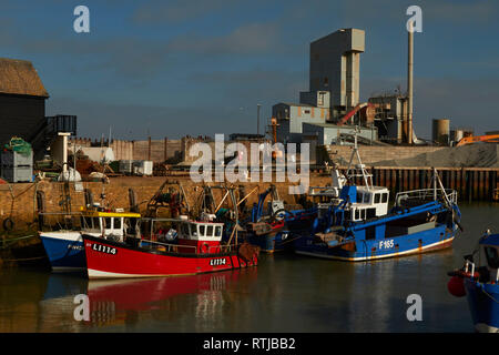 Bateaux dans Whitstable Harbour avec Brett usine agrégats dans l'arrière-plan sur un ciel bleu jour, Whitstable, Kent, Angleterre, Royaume-Uni Banque D'Images