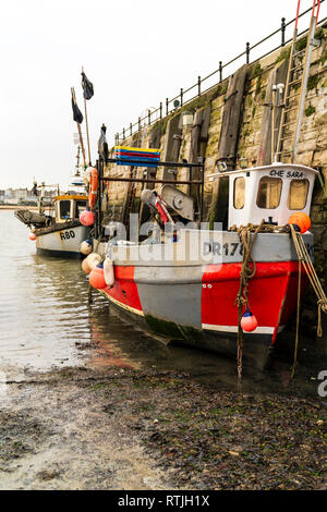 Deux petits bateaux de pêche amarrés cabine simple l'un derrière l'autre contre le mur de pierre de Margate harbour, avant un demi-sec, à cause de la marée basse. Banque D'Images