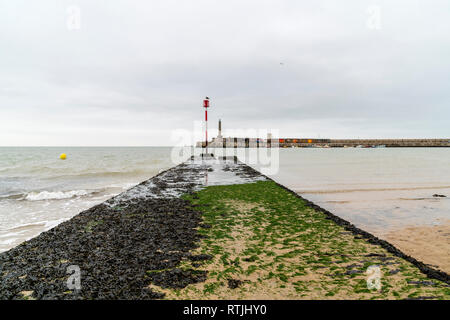 Front de mer de Margate. Vague béton recouvert d'algues avec disjoncteur pôle de navigation sur l'extrémité du port, avec en arrière-plan. Ciel couvert ciel gris. Mer calme. Banque D'Images