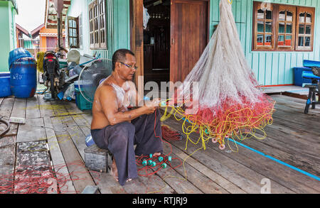 KOH CHANG, THAÏLANDE - 3 mars, 2015 : hommes tissent un filet de pêche dans le village Banque D'Images