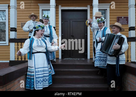 Groupe folklorique bélarussien dans un vêtement traditionnel chantant des chansons folkloriques à l'entrée du musée des arts folkloriques Motal à Motol ou Motal un canton d'Ivanava Raion de la région de Brest Banque D'Images