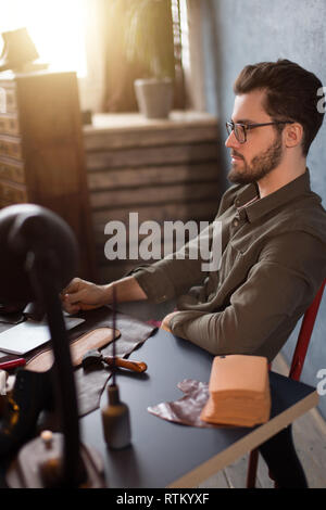 Créateur de chaussures ayant un reste en position assise au travail. close up side view photo. Banque D'Images