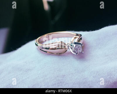 Close up d'une élégante bague en diamant sur le lit avec blanc et rose bouquet de fleurs séchées, de fond et de soft focus sélectif.love and wedding concept. Banque D'Images