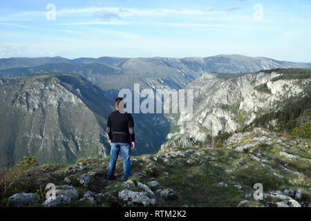 Jeune homme se tient au bord du Canyon et de la rivière Tara Tara - Parc national de Durmitor. Près de Zabljak, au Monténégro. Banque D'Images