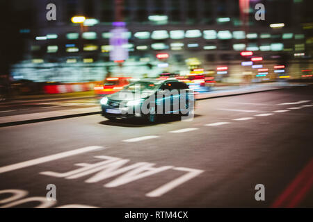 Flou artistique abstrait en mouvement la voiture conduite rapide à destination sur la rue de Londres la nuit - entreprise de transport avec thème motion de flou artistique sur le bus lane et bokeh Banque D'Images