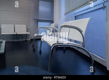 Dans la salle d'attente des médecins de l'hôpital moderne hall d'accueil avec des sièges vides et des tonalités sol bleu Banque D'Images