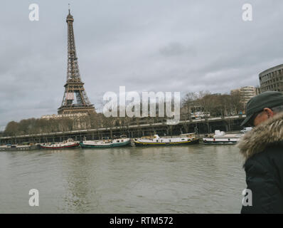 PARIS, FRANCE - Jan 30, 2018 : senior man parisien regarder la Seine près de la Tour Eiffel comme le dépassement de la rivière remblais après des jours de forte pluie Banque D'Images