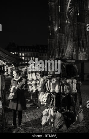 STRASBOURG, FRANCE - NOV 21, 2017 : femme femme choisissant de laine tricoté des bonnets et chaussettes dans la PLace de la cathédrale un jour avant le début du marché de Noël - image en noir et blanc Banque D'Images