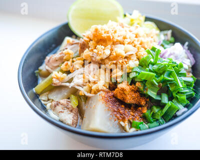 Déchiquetez les nouilles instantanées poulet frit avec de l'ail. le chili en poudre, citron, oignon de printemps et de la soupe avec les épices dans un bol sur le tableau blanc Banque D'Images