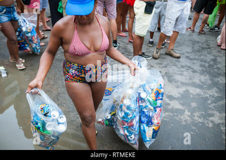 RIO DE JANEIRO - février 11, 2017 : une femme brésilienne possède une collection de poubelles pour le recyclage à la suite d'une fête de rue Carnaval d'Ipanema. Banque D'Images