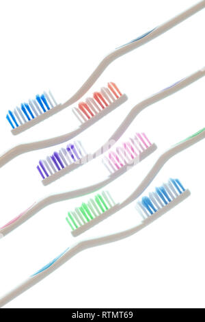 Vue côté vertical shot de 6 brosses à dents colorés avec des poignées blanches posées en diagonale isolé sur blanc. Banque D'Images