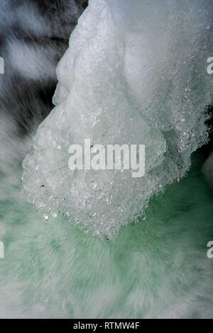 Fragment de la cascade en hiver. La projection d'eau gelée dans le contexte de l'eau bouillante de couleur Banque D'Images