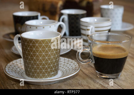 Service de coffee cup avec en premier plan un verre tasse d'expresso Banque D'Images