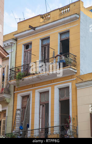 La Havane, Cuba - 06 janvier 2013 : une vue sur les rues de la ville avec des cubains. Une femme assise sur le balcon. Banque D'Images